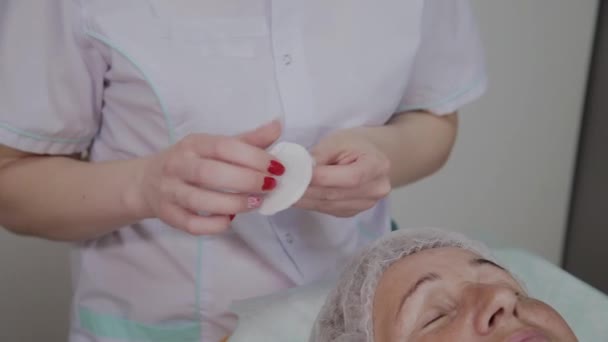 Beauticijština provádí postup praní obličeje starší ženy v Kosmetologické klinice. — Stock video