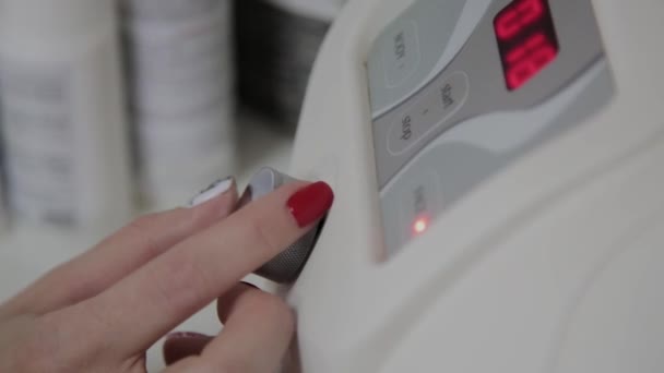 A professional cosmetologist includes a device for microcurrents in a cosmetology office. — Stock Video