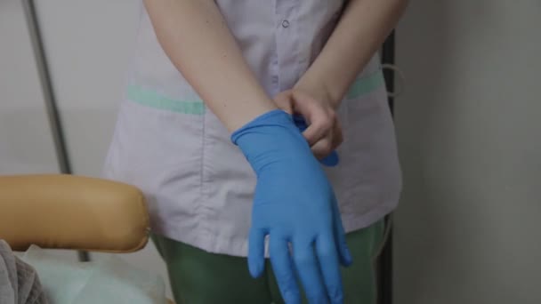 Профессиональный косметолог носит синие резиновые перчатки для процедуры . — стоковое видео