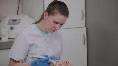 Profesyonel kozmetoloji ofisinde mikroakımlı yaşlı bir kadın için işlem yapar.