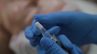 Profesyonel güzellik kozmetoloji ofisinde serum şişesi açar