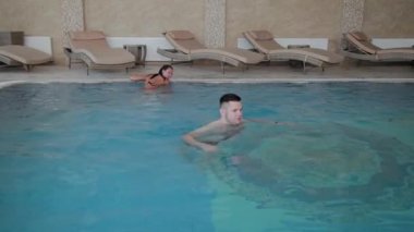 Erkek ve kadın havuzda yüzmek.