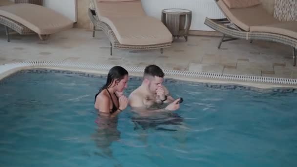 Férfi és nő úszik a medencében. — Stock videók