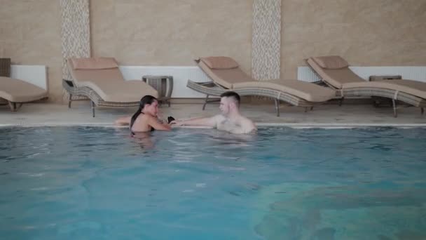 Чоловік і жінка плавають у басейні . — стокове відео