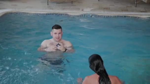 Man och kvinna simmar i poolen. — Stockvideo