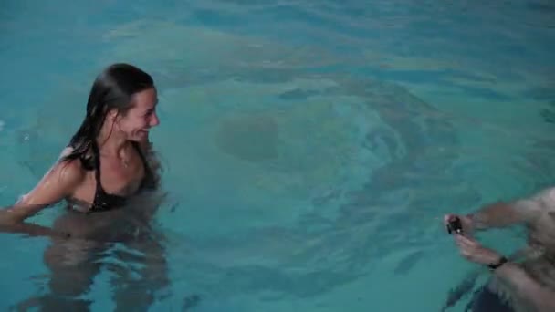 Άντρας και γυναίκα κολυμπούν στην πισίνα. — Αρχείο Βίντεο