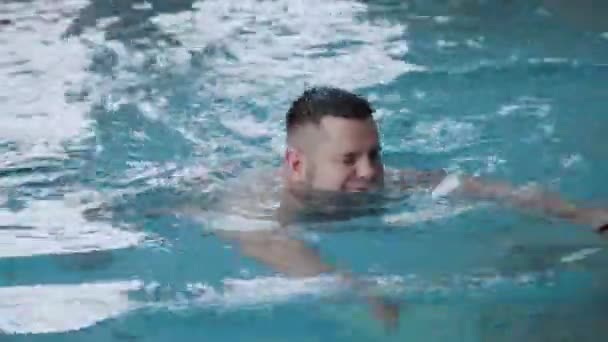 Genç adam kapalı havuzda yüzüyor. — Stok video