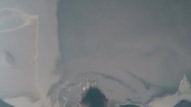 Neşeli komik adam havuzda yüzer. Havuzun dibinde aksiyon kamerası.