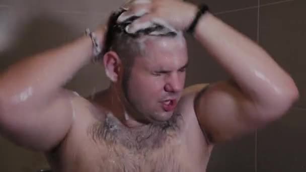 Joyeux homme drôle se lave sous la douche . — Video