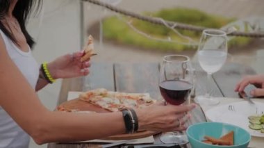 Bir restoranda terasta kırmızı şarap içen güzel kadın.