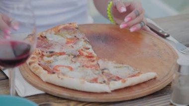 Bir kadın yemekleri pizzadan kızarmış tavuk kanatlarına değiştiriyor..