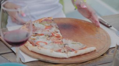 Bir kadın yemekleri pizzadan kızarmış tavuk kanatlarına değiştiriyor..