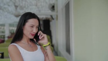 Restoranın terasında telefonda konuşan güzel kadın.