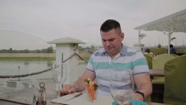 한 남자가 식당에서 채소 한 잔을 가져왔습니다. 건강한 음식. — 비디오