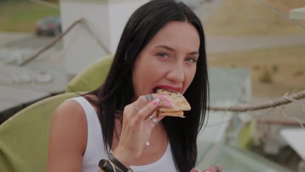 Bir restoranın terasında pizza yiyen güzel kadın. — Stok video