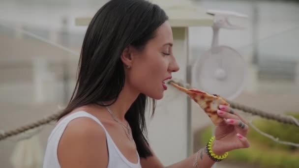 Όμορφη γυναίκα τρώει πίτσα στη βεράντα του εστιατορίου. — Αρχείο Βίντεο