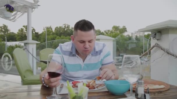Um homem come comida de plástico num restaurante. . — Vídeo de Stock