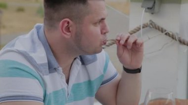 Bir adam hevesle bir restoranda abur cubur yiyor.