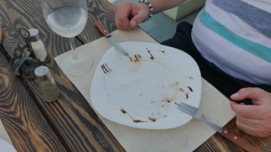 Genç adam bir restoranda masaya salata ile bir tabak koymak.