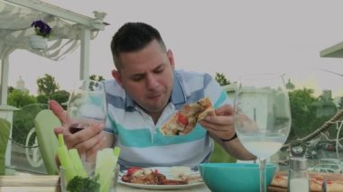 Bir adam hevesle bir restoranda abur cubur yiyor.