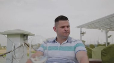 Genç bir adam bir restoranda bir masada oturur.