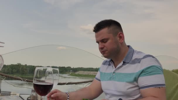 Un jeune homme déjeune avec une salade de légumes dans un restaurant sur la terrasse ouverte. Aliments sains . — Video