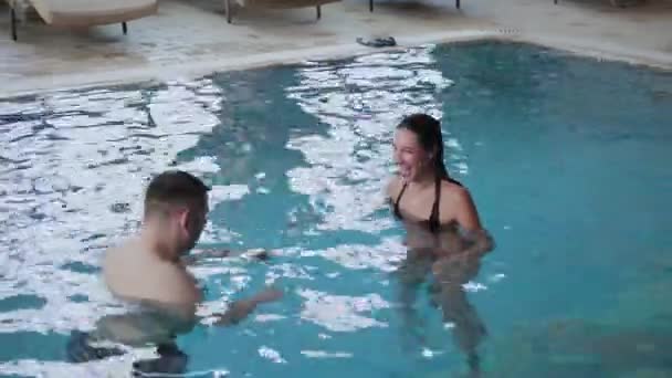 Jeune homme et femme plaisantant et souriant dans la piscine . — Video