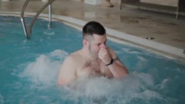 Jakuzi havuzunda yüzen neşeli komik adam.