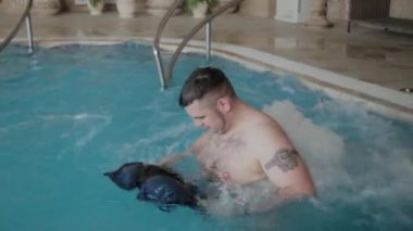Neşeli komik adam havuz jakuzide yıkar ve onun şort yıkar.
