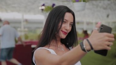 Güzel bir kadın ve neşeli bir adam restoranın verandada selfie çekmek.