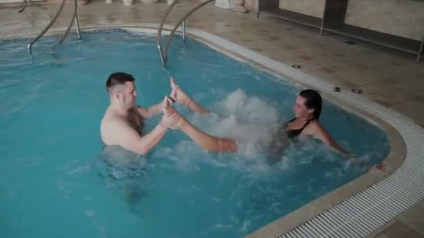 Junge Männer und Frauen scherzen und lächeln im Pool. — Stockvideo