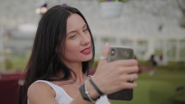 Gyönyörű nő hogy selfie a verandán az étterem. — Stock videók