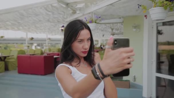 Hermosa mujer haciendo selfie en la terraza del restaurante . — Vídeos de Stock
