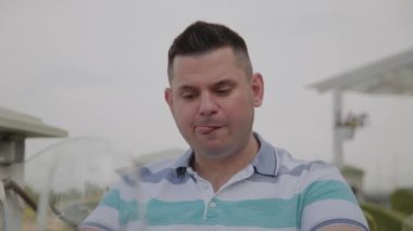 Genç bir adam bir restoranda bir masada oturur.