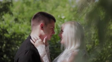 İki aşık güneşli havalarda bir ağacın altında oturup birbirlerine bakın ve gülümseyin.