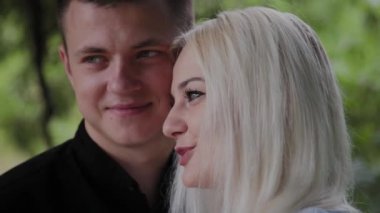 İki aşık güneşli havalarda bir ağacın altında oturup birbirlerine bakın ve gülümseyin.