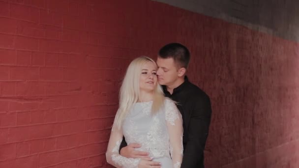 Счастливая влюбленная пара, стоящая под аркой дома и держащаяся за руки . — стоковое видео