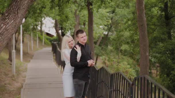 Heureux couple amoureux se tient sur la descente dans le parc sous les arbres . — Video