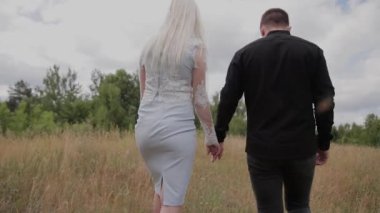 El ele tutuşarak tarlada yürüyen aşık güzel çift.
