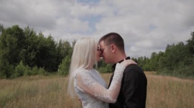 Aşık mutlu çift el ele tutuşarak sahada duruyor.