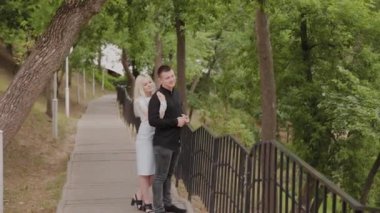 Aşk mutlu çift ağaçların altında parkta iniş duruyor.