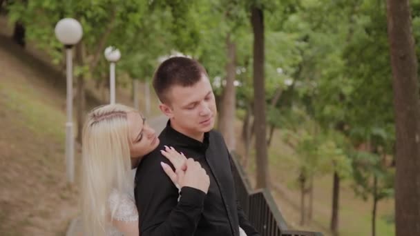 Heureux couple amoureux se tient sur la descente dans le parc sous les arbres . — Video