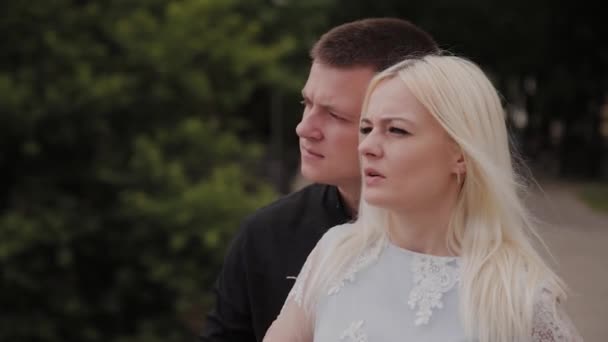 Boldog pár szerelmes állva a vashídon a városi parkban, és átölelve. — Stock videók