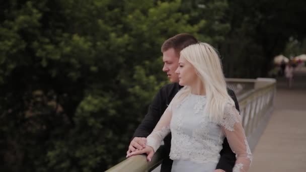 Couple heureux amoureux debout sur le pont de fer dans le parc de la ville et câlins . — Video