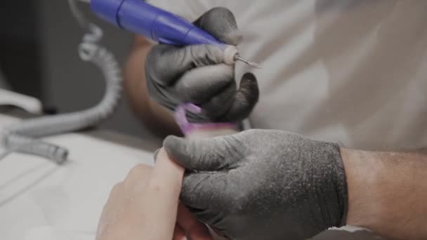 专业美甲师男子删除旧指甲油从女孩使用特殊的指甲油去除剂. — 图库视频影像