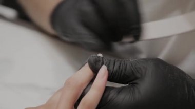 Profesyonel manikürcü adam parlatır ve bir tırnak dosyası ile kız çivi pürüzsüz.