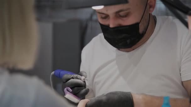 Profesjonalny manicurysta człowiek usuwa stary lakier do paznokci z dziewczyną za pomocą specjalnego zmywacz do paznokci. — Wideo stockowe