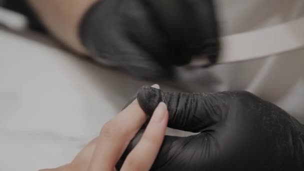 Professionele manicure man poliert en verzacht meisjes nagels met een nagel bestand. — Stockvideo