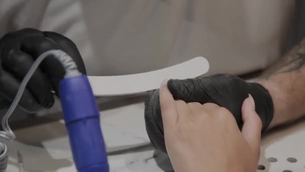 Profesionální manikúřník leštiče a uhlazuje dívky nehty se souborem nehtů. — Stock video