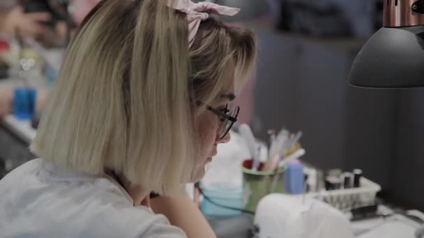 Professional manicurist man removes old nail polish from a girl using a special nail polish remover. — Stock Video